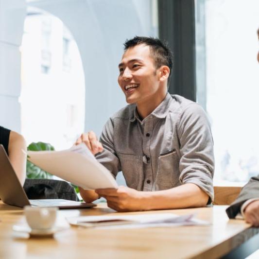 Young businessman in meeting with colleagues holding document
