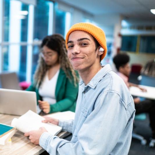 High school student smiling at the camera while in class