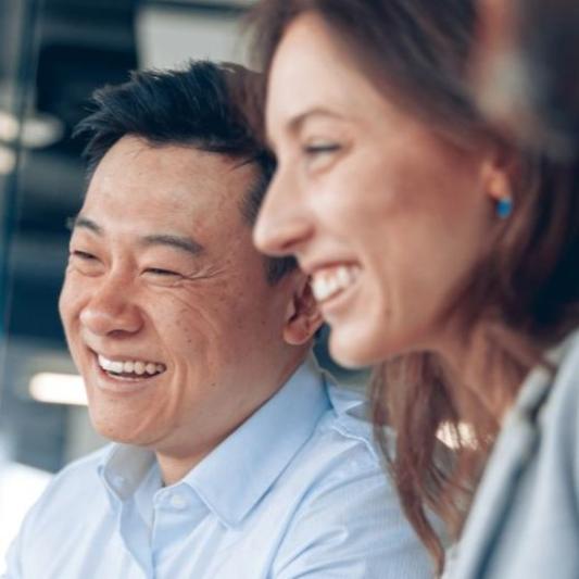 Close up of smiling colleagues in a meeting in a corporate office.