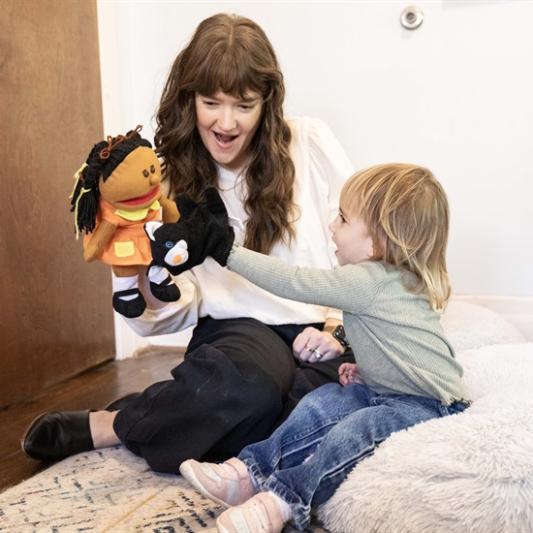 Therapist plays with a small child using sock-puppet therapy