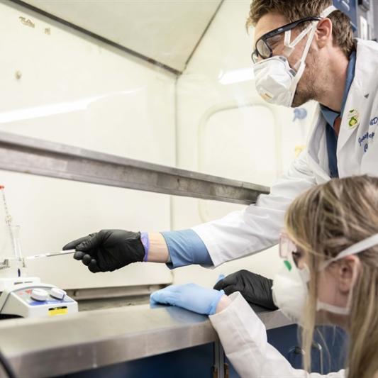 two chemists examining a beaker