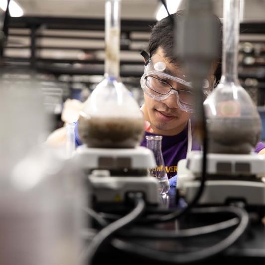 chemist behind beakers and equipment