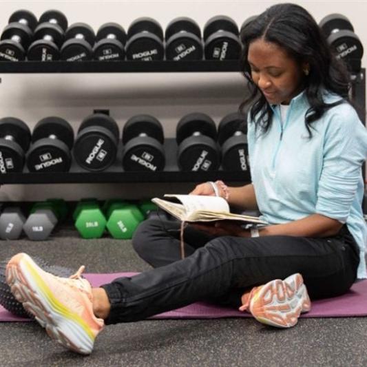 student stretching and studying pre-physical therapy