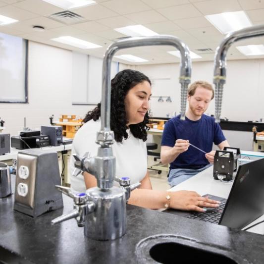 Madouna Barsoum and Ryan Dunn working with the NMR in the physics lab
