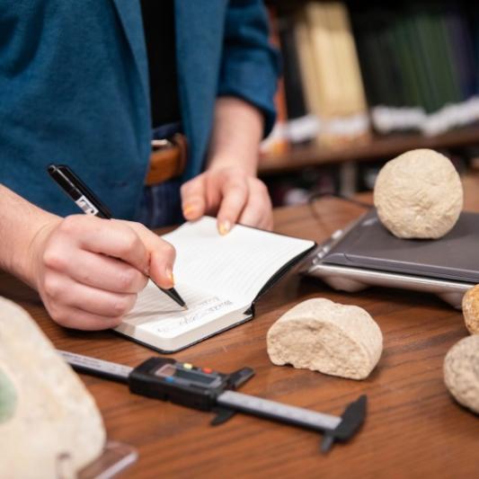 Students measuring stones for archaeological research