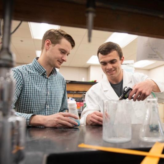Josh Owens working in the lab with a student