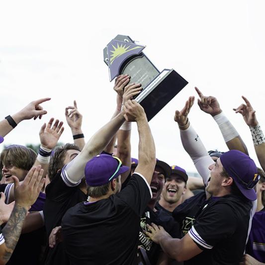 Baseball players lifting ASUN trophy. 