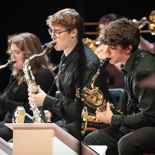 Students playing brass instruments in a band concert. 