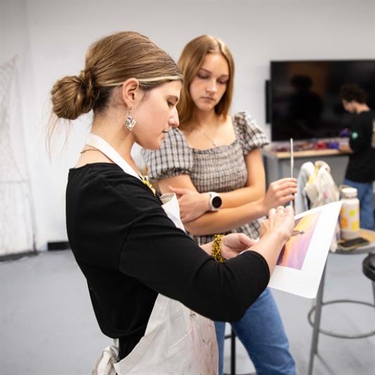 two women. one teaching art