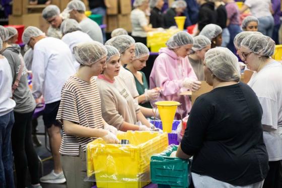 Volunteers pack meals to help hurricane victims. 