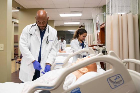 Lipscomb nursing students working with a SIM patient in the lab. 