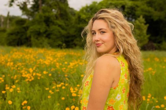 Zerita McAtee standing in a field of flowers. 
