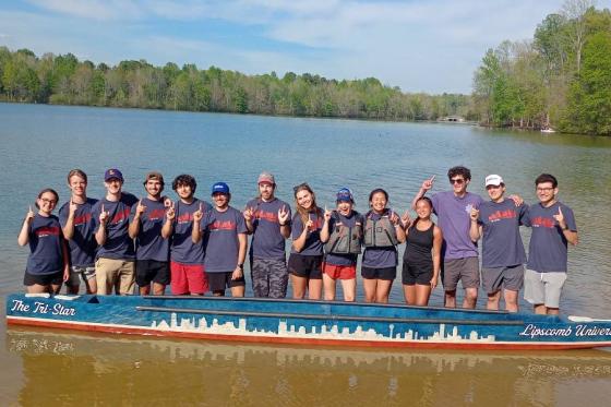 Concrete canoe team lined up with the canoe