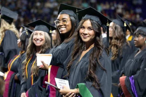 Students holding hoods during graduate commencement. 