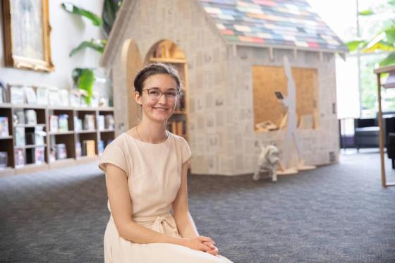 Hannah Fritsch sits in front of her book house creation. 