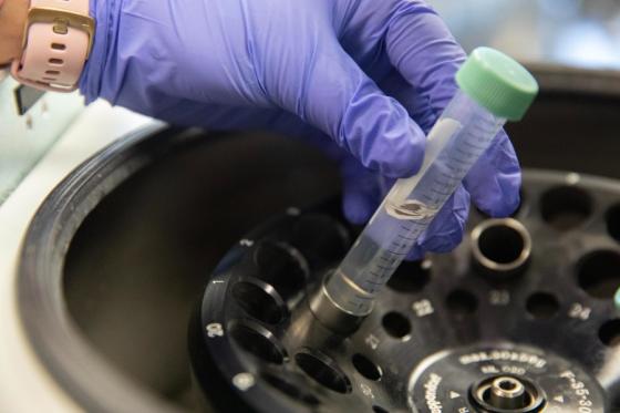 Hand of a lab worker working with a tube and the centrifuge