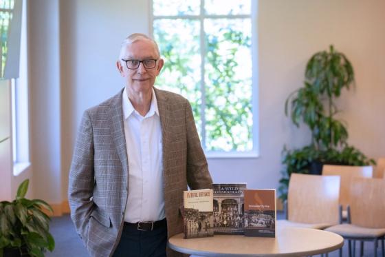 Leonard Allen posing with his three latest books on Church of Christ history