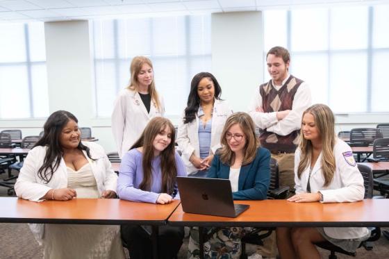 students in various health disciplines reviewing a patient case on a laptop