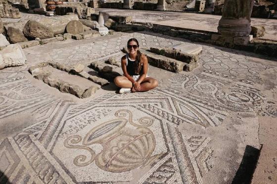 Kristen Flake sitting on an ancient mosaic floor