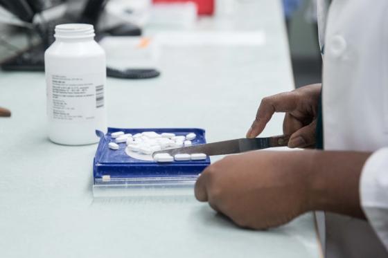 a pharmacist's hands dividing up pills for an order