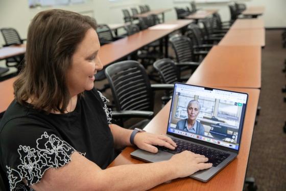Sarah Uroza showing off the AI avatar used in her course on her laptop computer