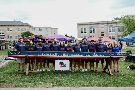 Concrete canoe team standing by the vessel