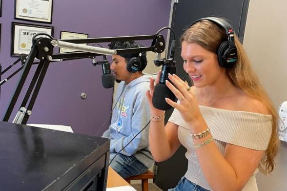 Samuel Espinoza and Olivia DeRocher anchor the award-winning newscast for The Bison. They are sitting in the sound booth wearing headphones.