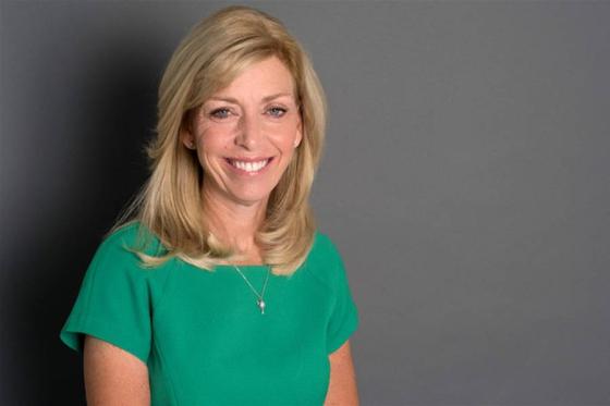 Photo of Beth DeBauche in front of a gray background. 
