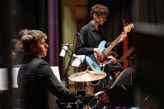 Two students playing musical instruments on stage