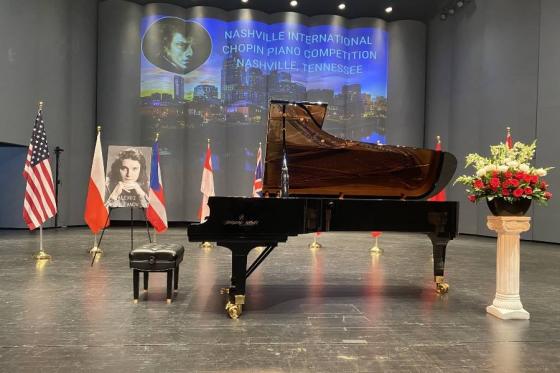 Grand piano on stage with country flags surrounding it