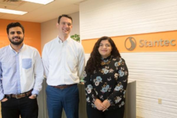 Three people standing in the lobby of an engineering firm.