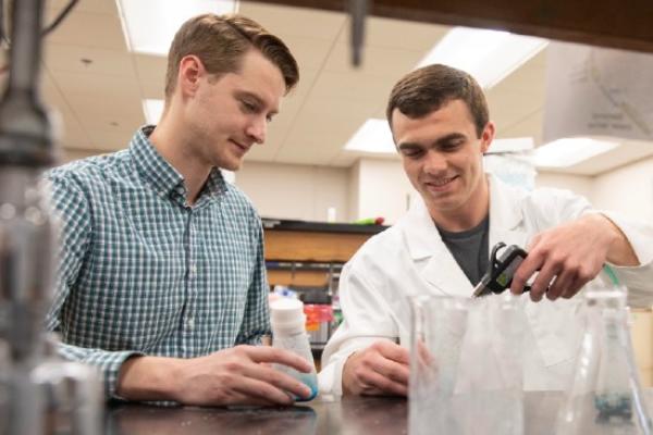 Josh Owens working with a student in the lab